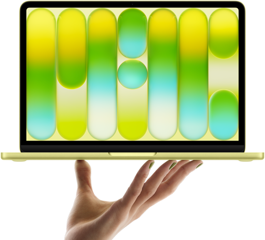 開いた手の指先がシトラスのMacBook Neoをバランス良く支えている。画面にはカラフルで抽象的なパターンが表示されている