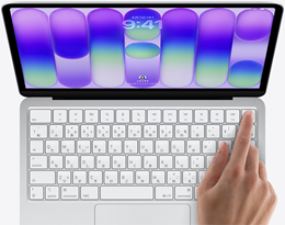 シルバーのMacBook Neo。ログイン画面が表示されていて、キーボードの右上角にあるTouch IDセンサーの上に指が置かれている